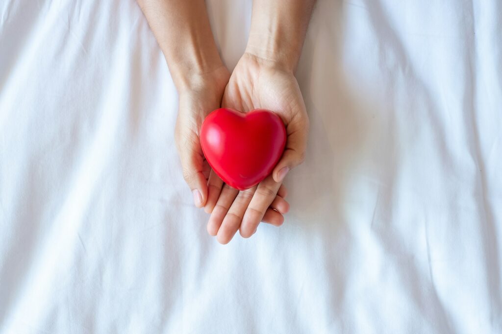 Woman holding Red heart shape, life Insurance, donation, health and World Heart Day concept